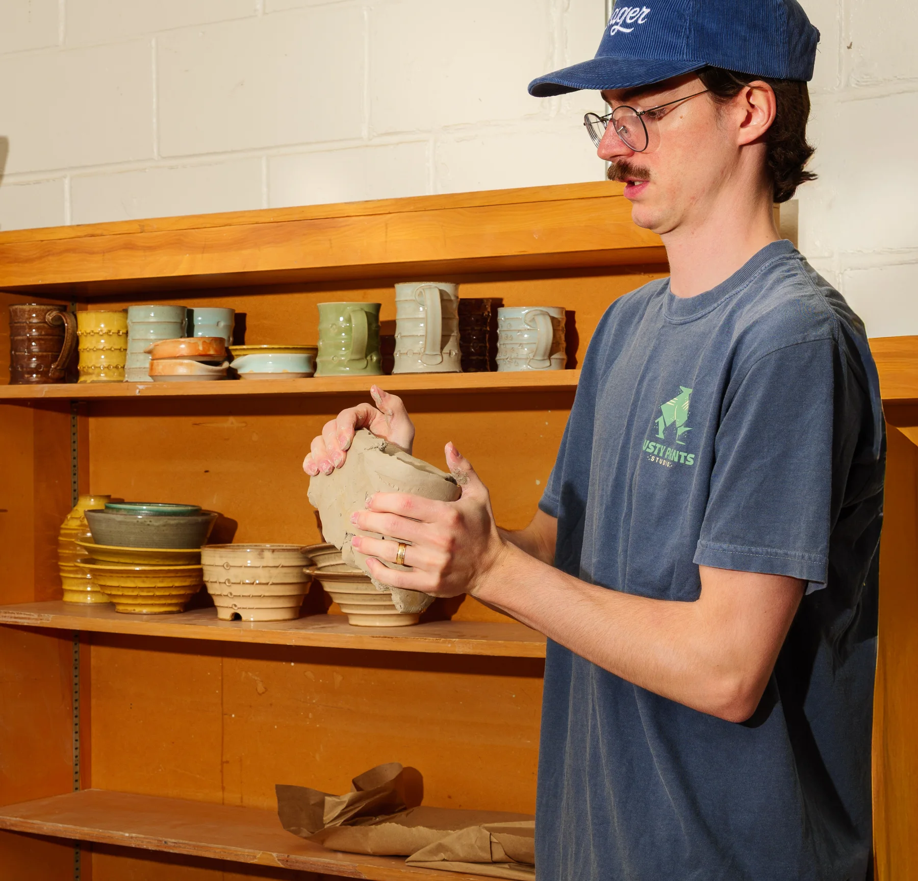 Young artist shaping clay at CASA