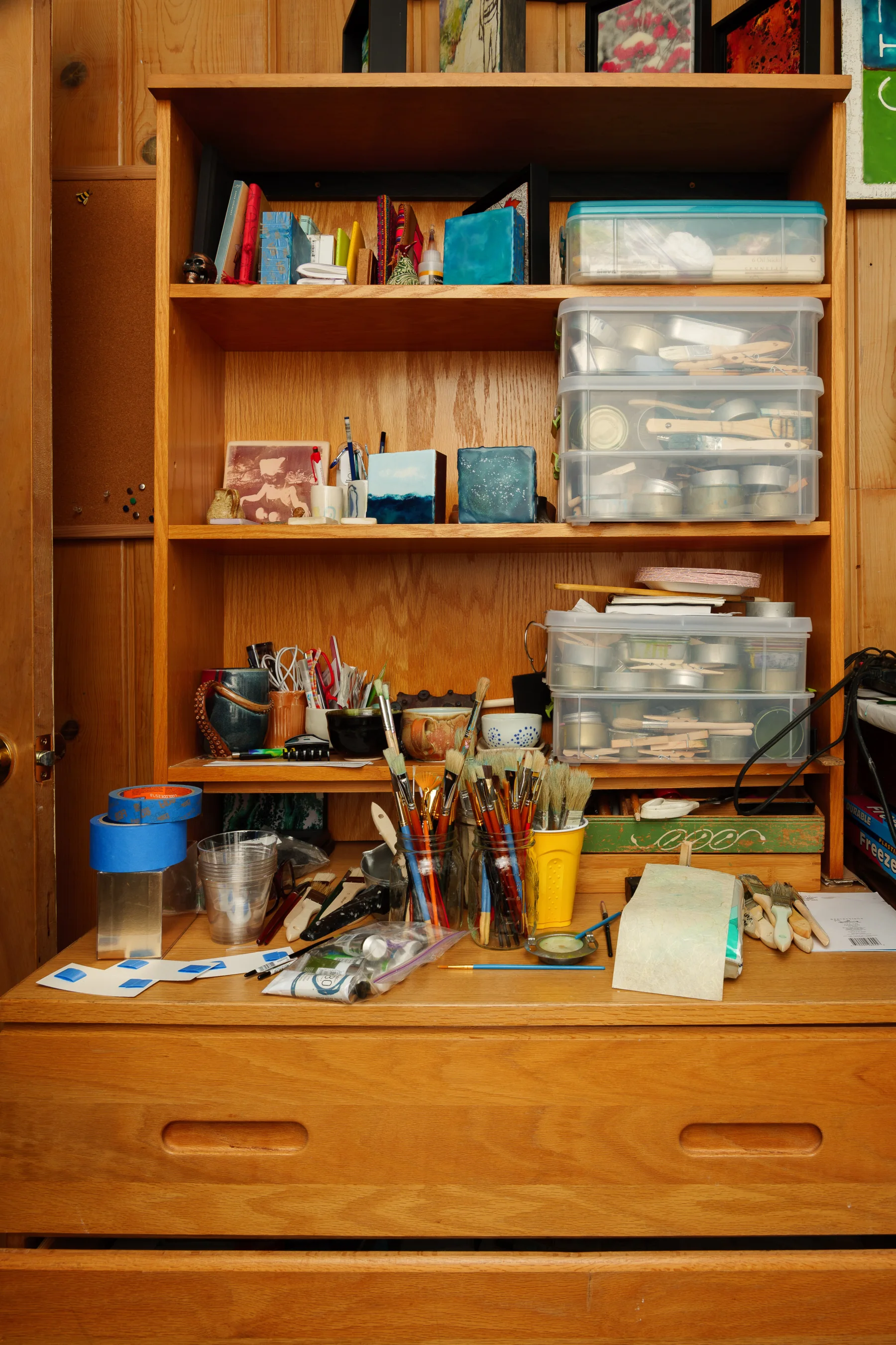 Organized art supplies and tools in a wooden cabinet at CASA